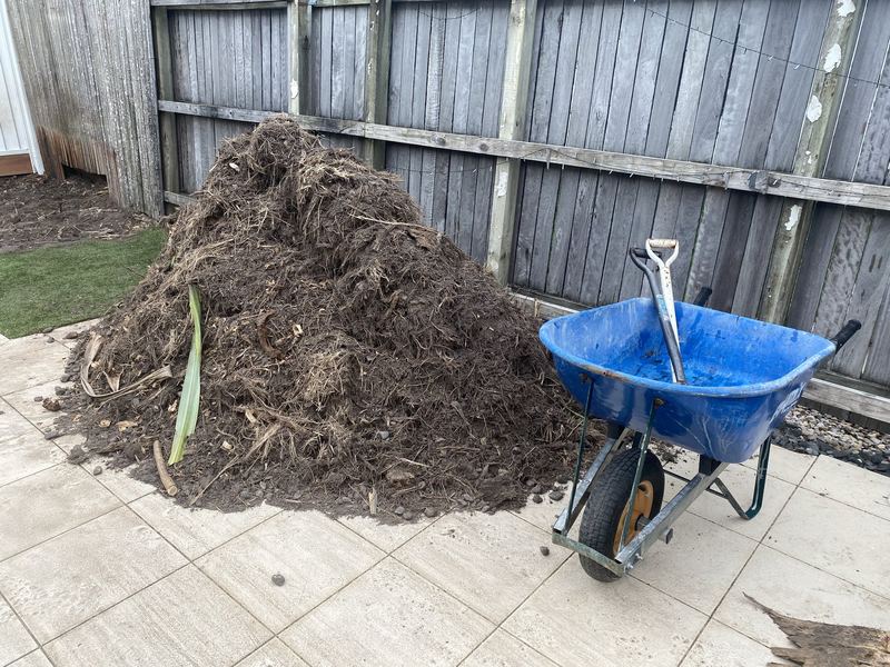 Backyard with a large pile of green waste before removal